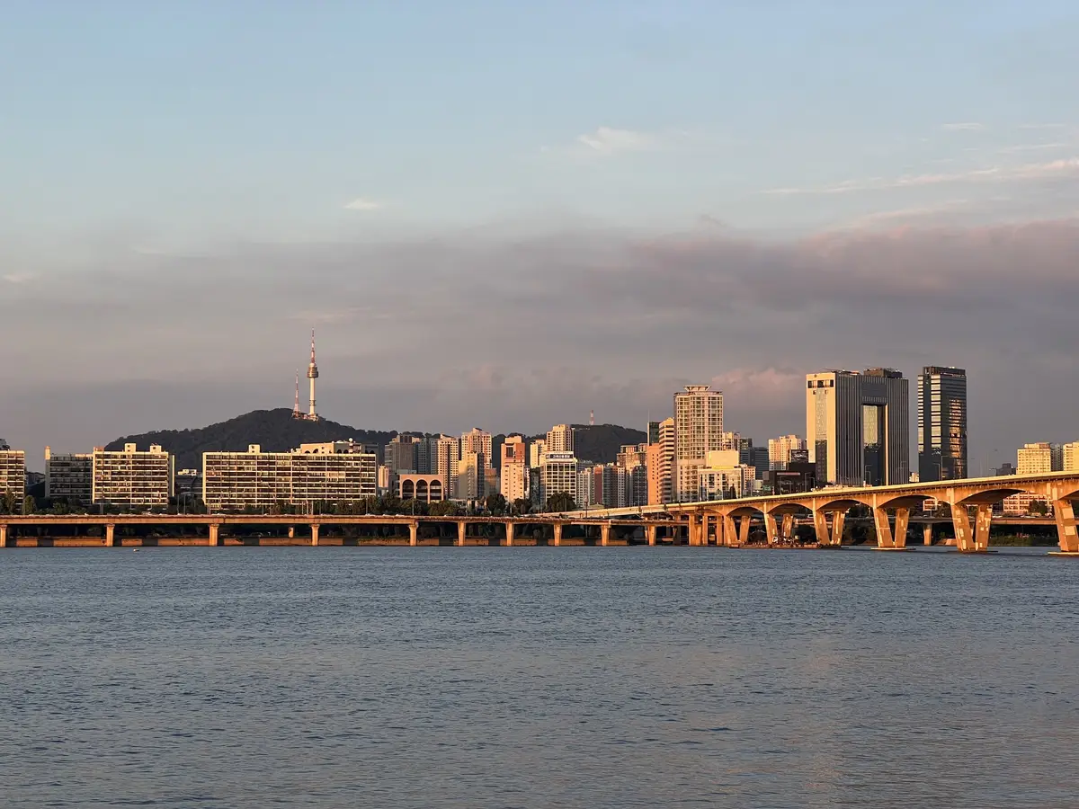 Namsan and N Seoul Tower across the Han River at golden hour, an arched bridge on the right